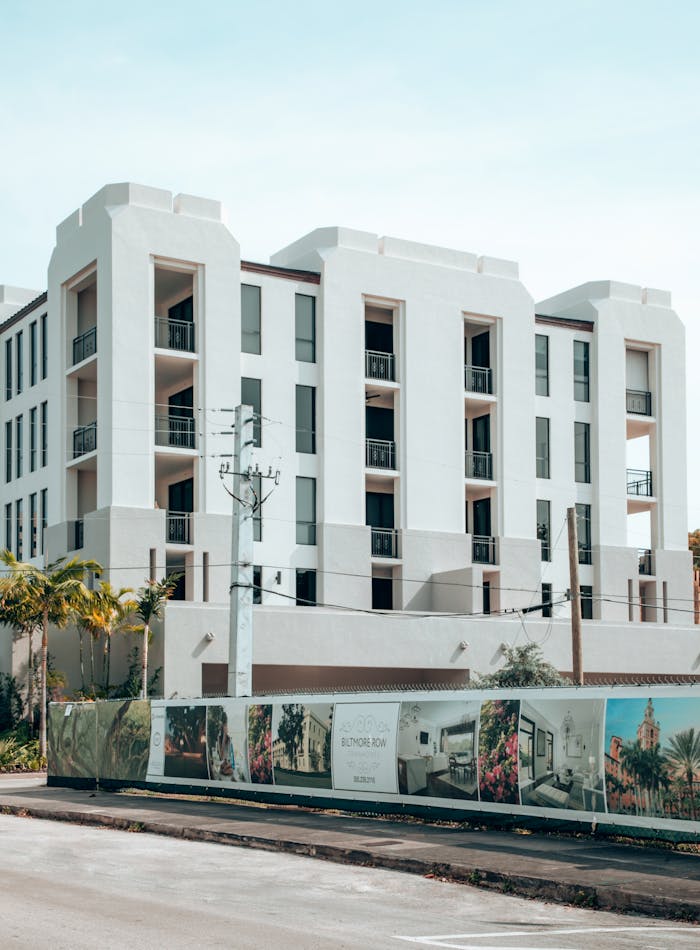 services-02 Elegant modern apartment building exterior in Coral Gables, Florida, under a clear blue sky.
